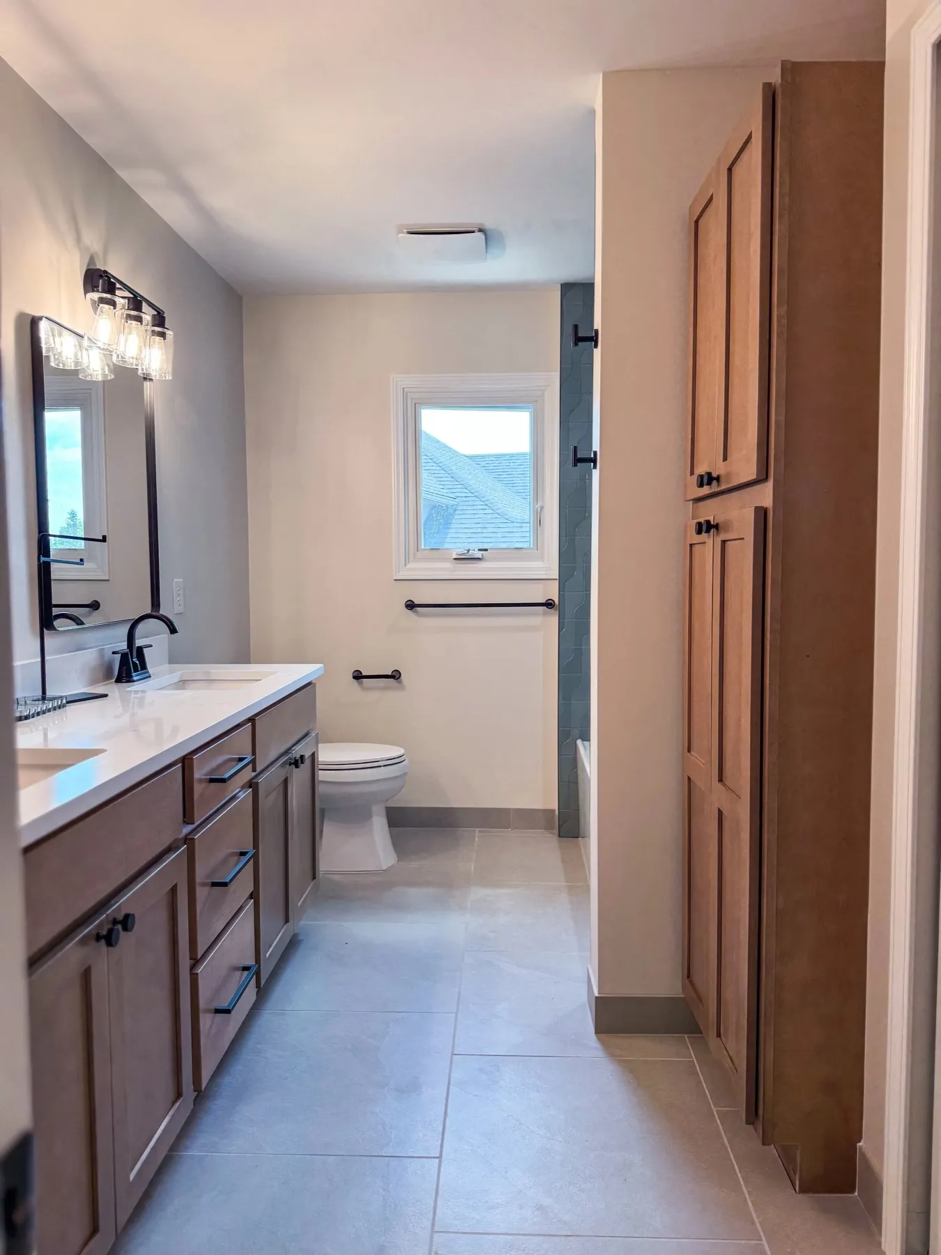 Bathroom vanity with a framed mirror and sconce lighting next to a wood door