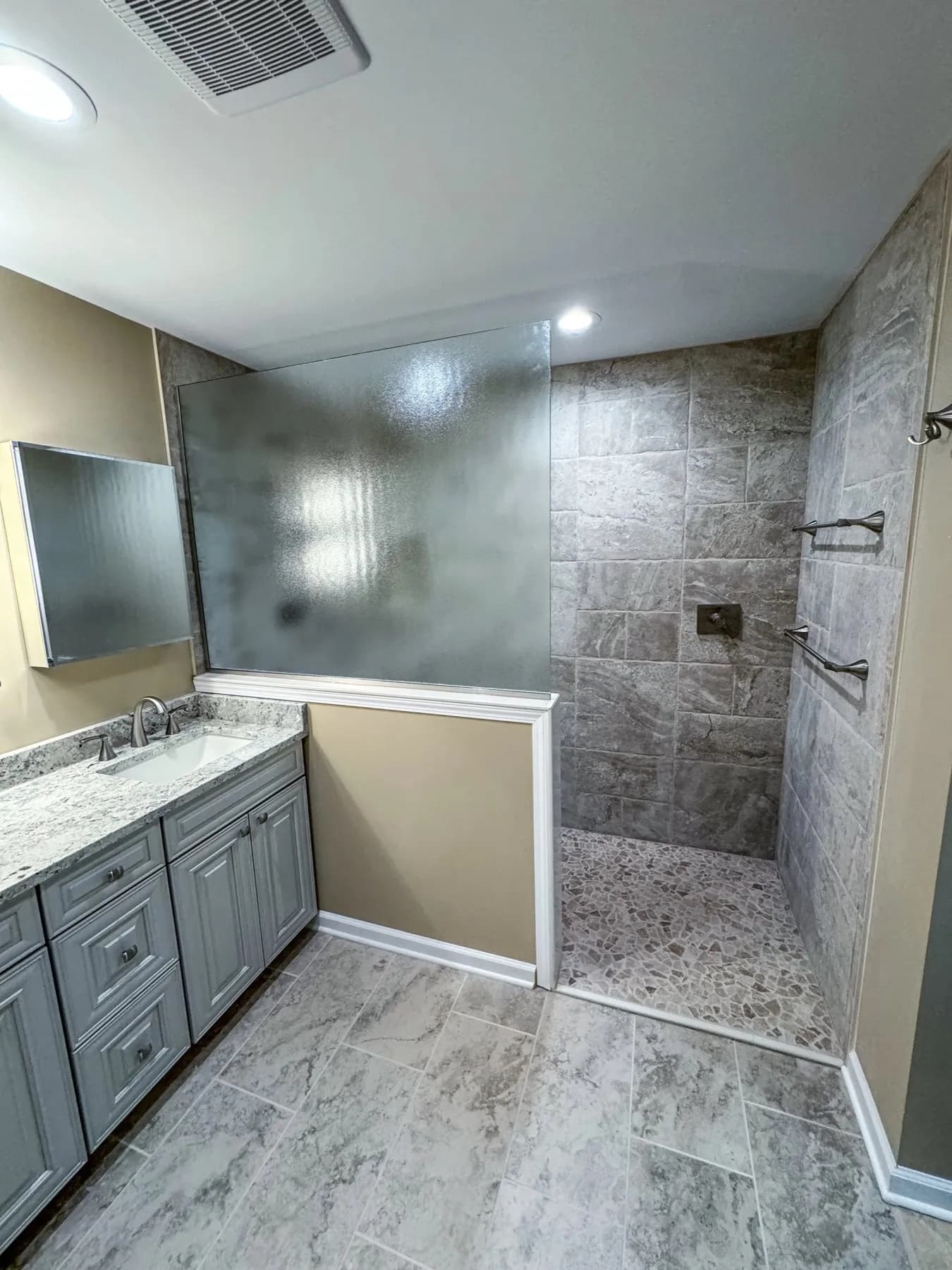 Bathroom with a curbless tile walk-in shower and a gray vanity