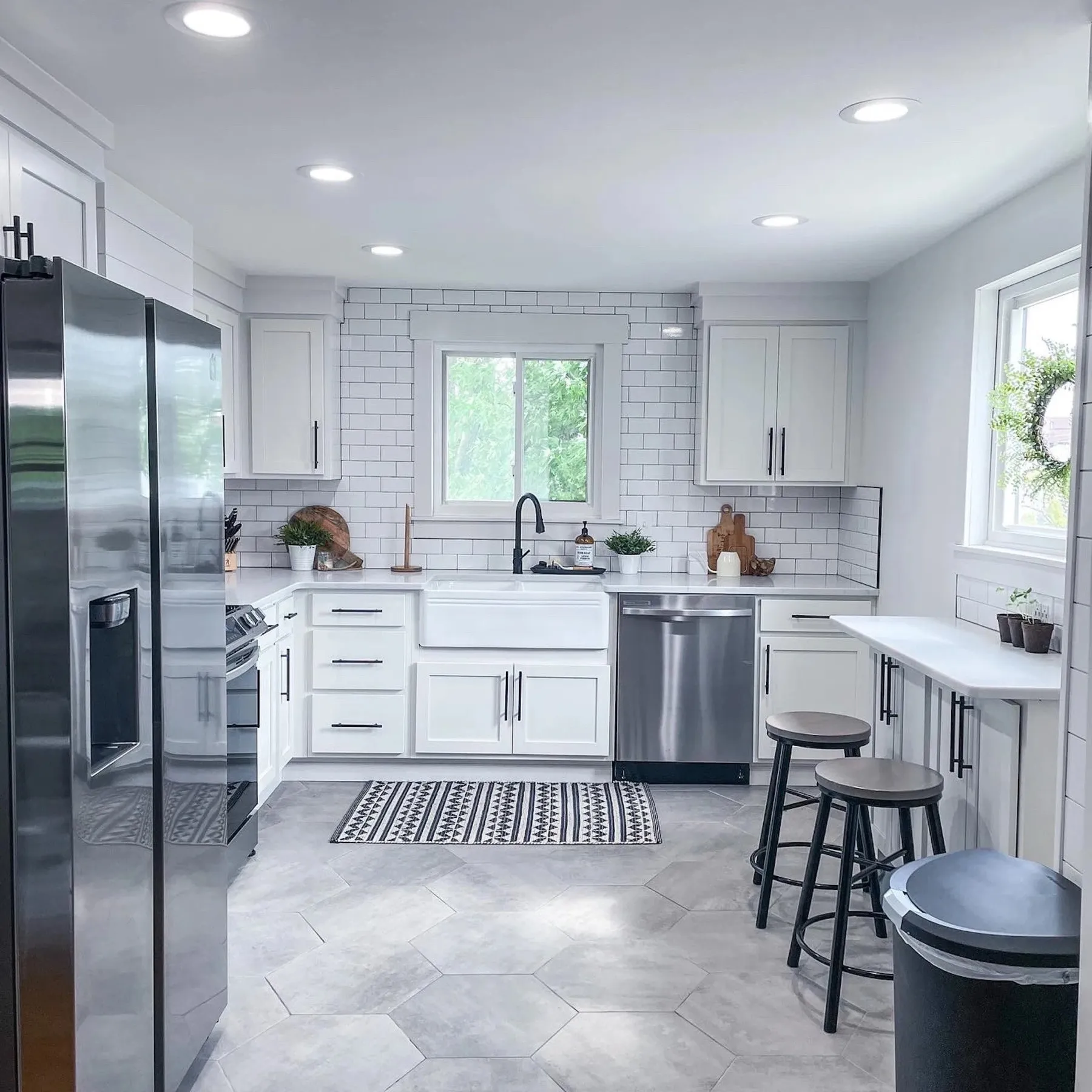 Open kitchen with white cabinets, a tile floor, and an island with counter stools